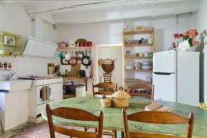 a kitchen with a table with chairs and a refrigerator at Mas Ferrer Petit by 123ole in Sant Andreu del Terri