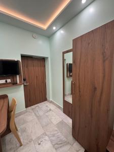 a room with a door and a television and a chair at HOTEL SREE DURGA in Kolkata +73 photos