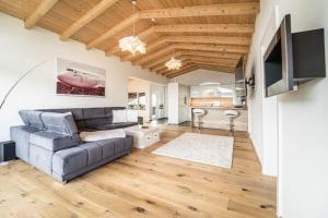 a living room with a couch and a kitchen at Tyrolhaus in Grinzens
