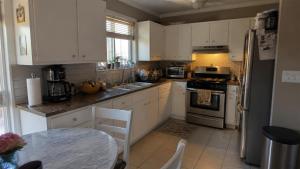 a kitchen with white cabinets and a table in it at Dream Stay in Schwanewede