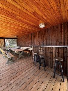 a room with two tables and stools in a cabin at Z Nurtem Rzeki Domy z basenem Podlasie in Korycin