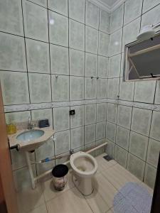 a bathroom with a toilet and a sink at Kitnet Centro in Capitólio