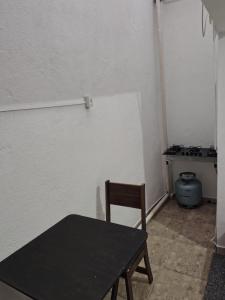a black table and a chair in a room at Kitnet Centro in Capitólio