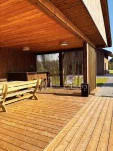 a wooden deck with a bench on top of it at Z Nurtem Rzeki Domy z basenem Podlasie in Korycin