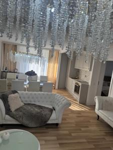 a living room with a white couch and a chandelier at Talna Luna Ses in Negreşti-Oaş