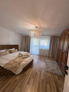 a bedroom with a large bed and a chandelier at Talna Luna Ses in Negreşti-Oaş