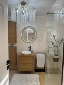 a bathroom with a chandelier and a sink and a mirror at Talna Luna Ses in Negreşti-Oaş +47 photos