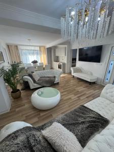 a living room with white furniture and a chandelier at Talna Luna Ses in Negreşti-Oaş