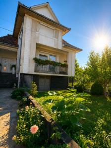 a house with a flower garden in front of it at Talna Luna Ses in Negreşti-Oaş