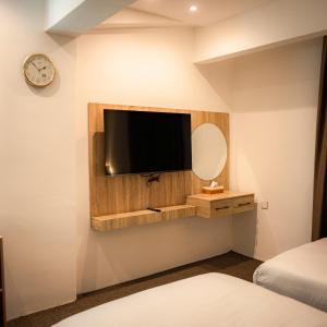 a bedroom with a tv on a wall with a mirror at Consal Hotel 康赛尔酒店 in Baghdād