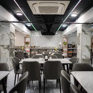 a restaurant with tables and chairs in a room at Consal Hotel 康赛尔酒店 in Baghdād