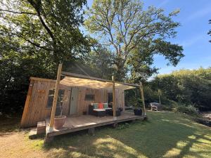 a wooden shed with a porch in the grass at Nesta's Nook in Llandovery