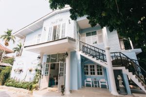 ein weißes Haus mit blauem Schnitt in der Unterkunft Nai Suan Bed and Breakfast in Chiang Rai