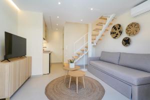 a living room with a couch and a tv at Villa Yanna in Olympiada