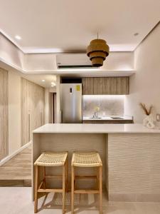 a kitchen with a counter and two stools at Suite Deluxe frente al Mar - Playa & GYM in Acapulco