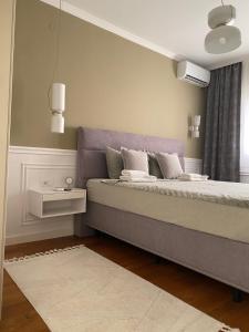 a bedroom with a bed with a purple headboard at Velvet Point apartmant in Kragujevac