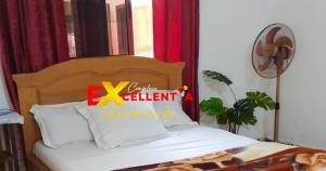 a bedroom with a bed with a sign on it at Appart meublé Excellentia Edea in Edéa