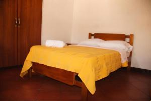 a yellow bed with two towels on top of it at La Casona Santa Fe in Santa Fe de Antioquia