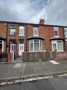 a brick building with a pink door on a street at Brook Terrace in Darlington