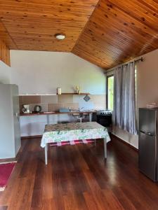 a kitchen with a table in the middle of a room at Studio indépendant in Otutara