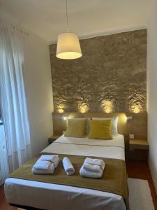 a bedroom with a bed with two towels on it at Casal Mala-Posta in Rio Maior