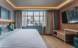 ein Schlafzimmer mit einem großen Bett und einem großen Fenster in der Unterkunft Hotel More By Kavia in Mexiko-Stadt
