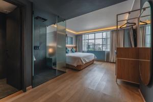 ein Schlafzimmer mit einem Bett und einer Glaswand in der Unterkunft Hotel More By Kavia in Mexiko-Stadt