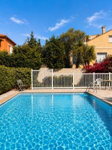 a blue swimming pool with a white fence at Cap et Soleil Peaceful Private Garden, 2 Terraces, Pool, Garage, 5 Min Walk to Beach in Antibes