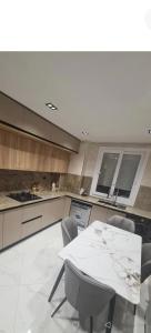 a kitchen with a white table and chairs in it at Nassim19 in Sétif +1 photo