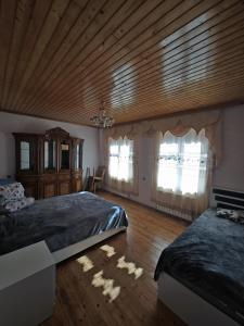 a bedroom with two beds and a wooden ceiling at Qebele Romi Family House in Vǝndam +9 photos