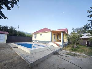a house with a swimming pool in the backyard at Qebele Romi Family House in Vǝndam