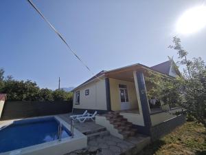 a small house with a swimming pool next to it at Qebele Romi Family House in Vǝndam