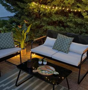a patio with a couch and a table and lights at Apartman Classy Pécs in Pécs