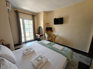 a bedroom with a bed with two towels on it at Villa Askamnia and Suites in Nikiti