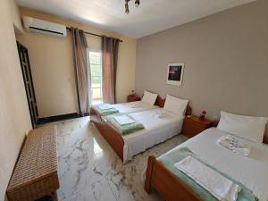 a hotel room with two beds and a window at Villa Askamnia and Suites in Nikiti +165 photos