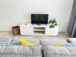 a living room with a couch and a flat screen tv at Apartamento T0 - MedSal Residence in Prainha