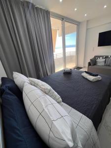 a bedroom with a large bed and a large window at Ble Property Atlas 6 in Loutraki