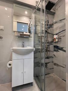 a bathroom with a sink and a shower at Ble Property Atlas 6 in Loutraki +58 photos