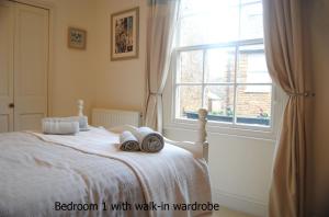 a bedroom with a bed with a window at High Street Apartment in Uppingham