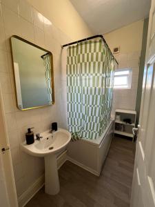 a bathroom with a sink and a mirror and a shower at The Blackburn 2 Bedroom House in Cherry Tree