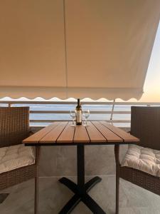 a table with two wine glasses and a bottle at Ble Property Atlas 6 in Loutraki
