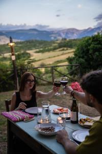 a group of people sitting at a table drinking wine at Borgo Majella by Rentbeat in Abbateggio