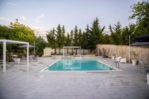 a swimming pool with chairs and a gazebo at Borgo Majella by Rentbeat in Abbateggio