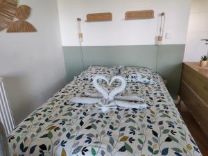 a bed with two swans made out of towels at Ti Malo - Appartement proche plage Dunkerque in Dunkerque