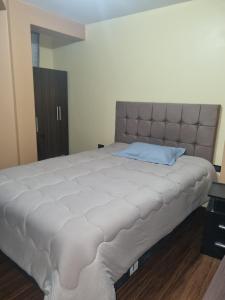 a large bed with a large headboard in a bedroom at Misky Samana Hotel in Espinar