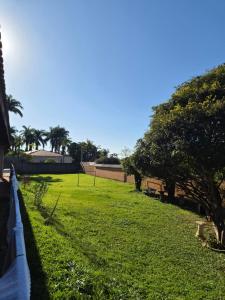 a field of grass with trees and a fence at Refúgio triplo por pessoa in Paulínia