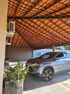 a car parked under a wooden pergola at Refúgio triplo por pessoa in Paulínia +2 photos