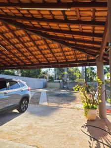 a car parked under a wooden pergola at Refúgio triplo por pessoa in Paulínia