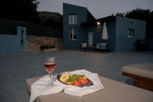 a plate of fruit and a glass of wine on a table at Angels luxury villa in Kastamonítsa