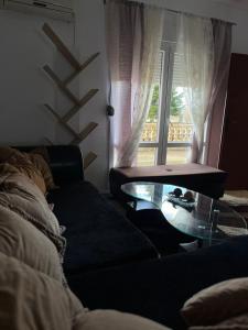 a living room with a couch and a glass table at Studio apartman Delic in Podgorica
